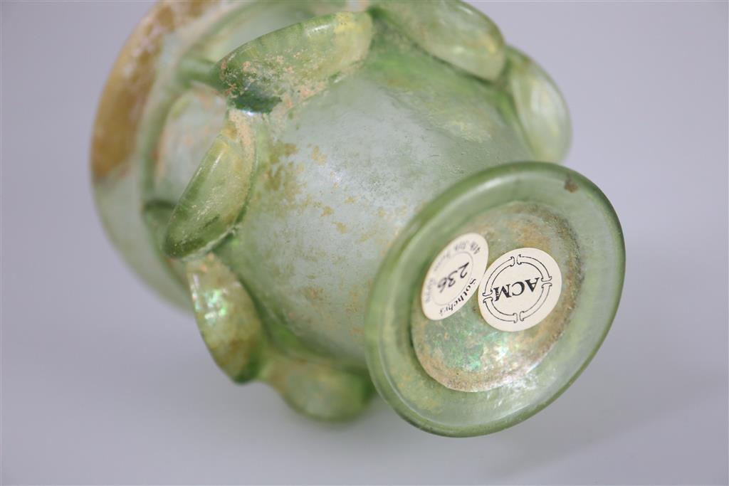 A Roman green glass auricular cup, 2nd/3rd century AD, 7.5cm high